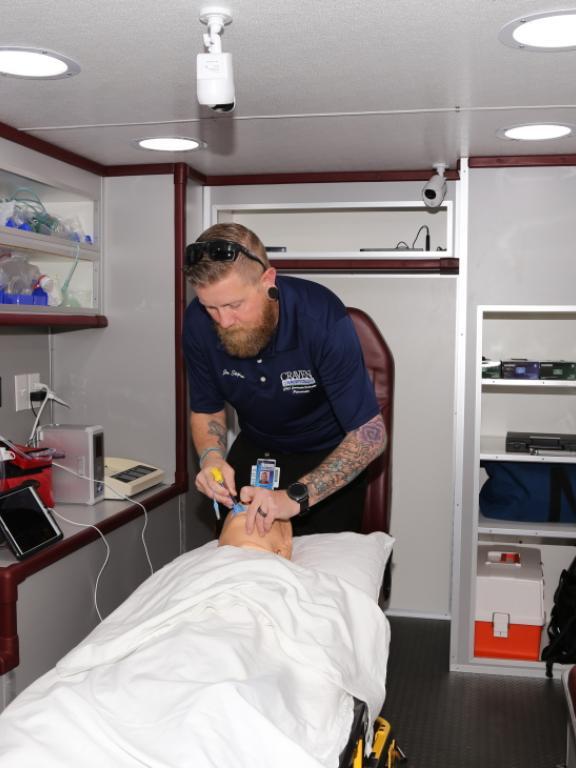 Jon Stephens, Craven CC EMS program coordinator and instructor, demonstrates placing a king airway in a patient simulator inside the college’s new ambulance simulator.