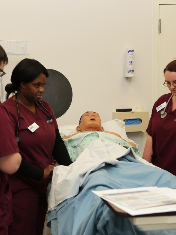 Nursing students tend to simulated patient in hospital bed