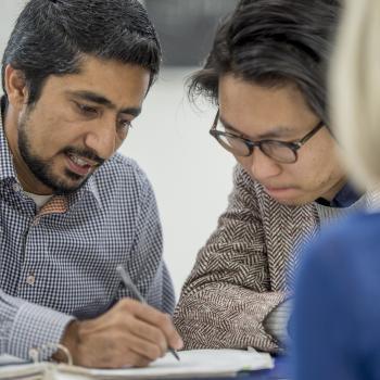 man holding pen with notebook collaborating with woman