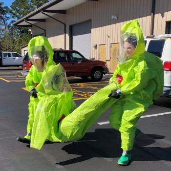 two students walking in hazmat suits