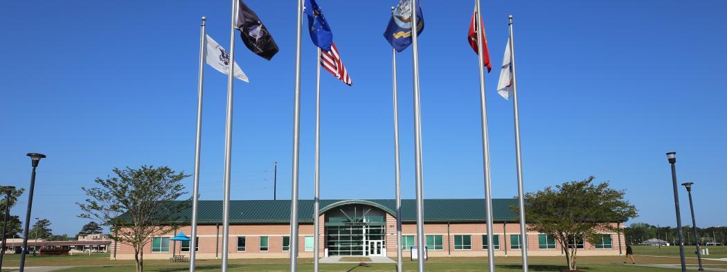 Havelock campus exterior with flags in courtyard