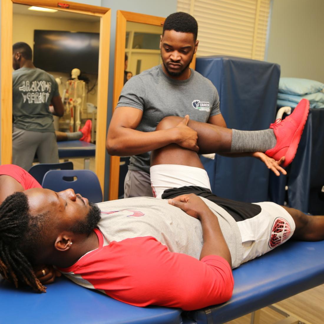 Craven CC Physical Therapist Assistant (PTA) program student Omar Howell performs a strengthening intervention on fellow student Tevin Meda. The PTA program is one of three health programs accepting applications through April 30.
